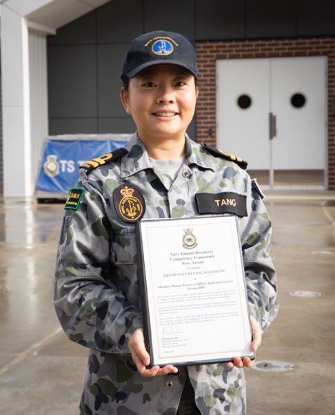A person in a uniform holding a certificate

Description automatically generated with low confidence